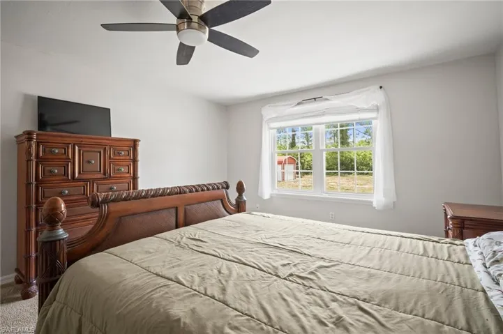 Bedroom featuring carpet floors, a ceiling fan, and baseboards