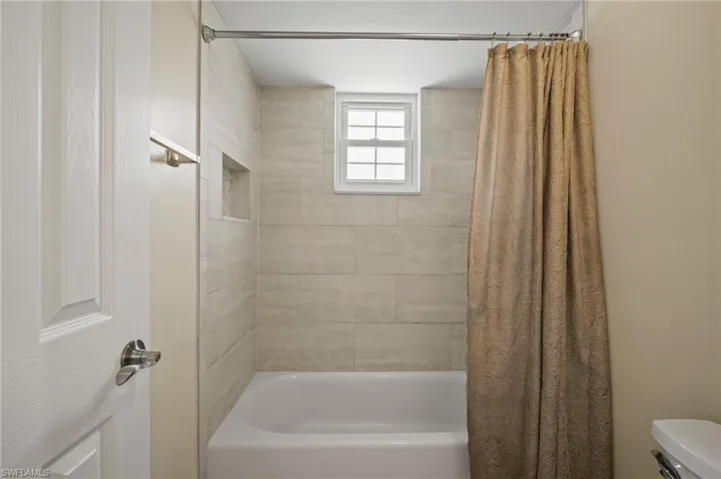 Full bath featuring shower / bath combo and toilet