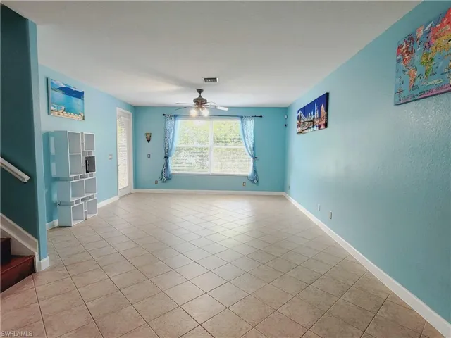 Living room with ceiling fan and tile floors