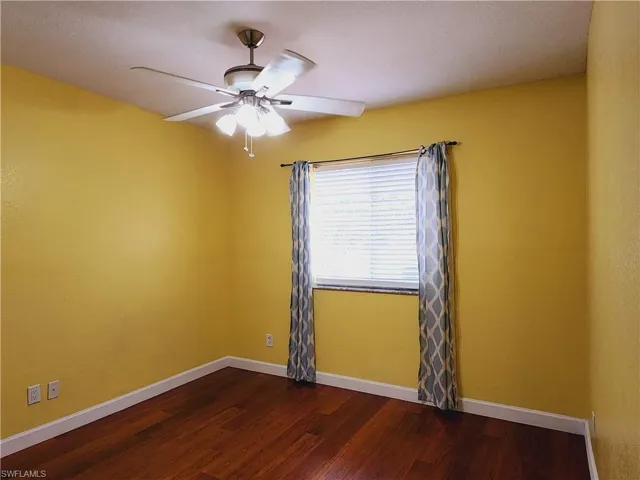Bedroom with ceiling fan and wood-type flooring