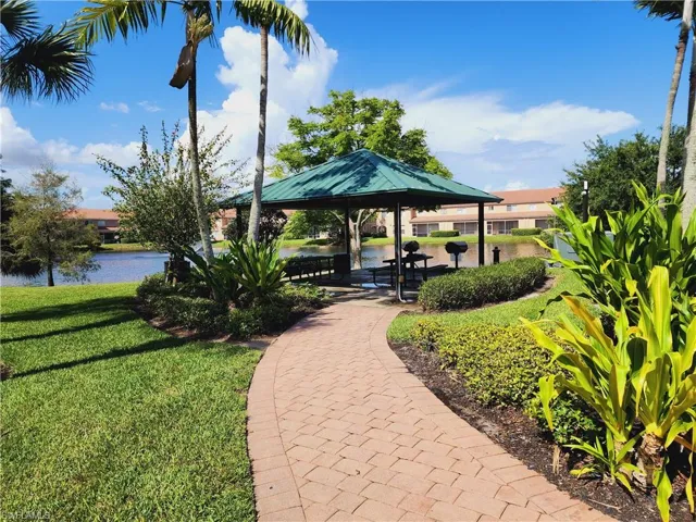 Community featuring a water view, a gazebo, and a lawn
