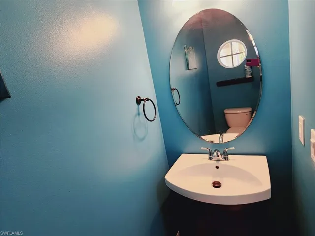 Bathroom featuring sink and toilet located left of floyer