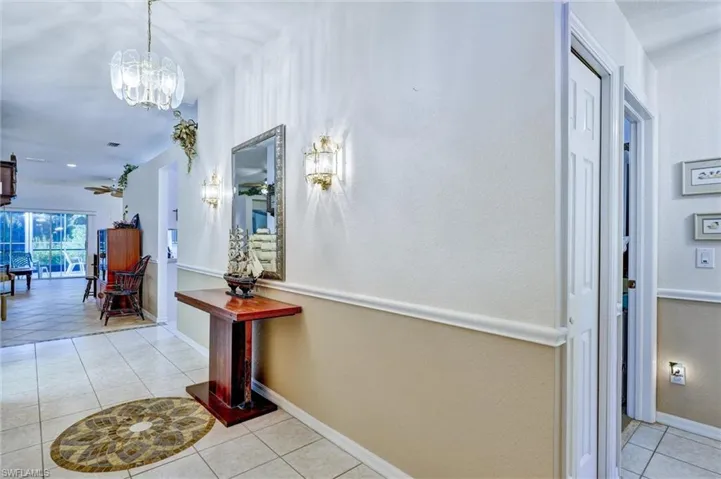 Entryway featuring tile flooring, wainscoting, and decorative wall sconces
