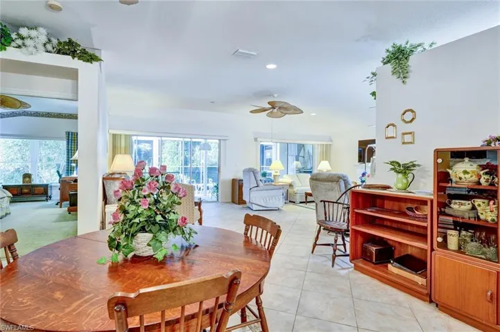 Open-concept living area featuring light-toned tile flooring, recessed lighting, and ceiling fans