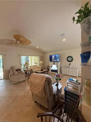The living area features vaulted ceilings, tile flooring, and a ceiling fan