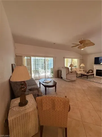 The living area features vaulted ceilings, tile flooring, and a ceiling fan