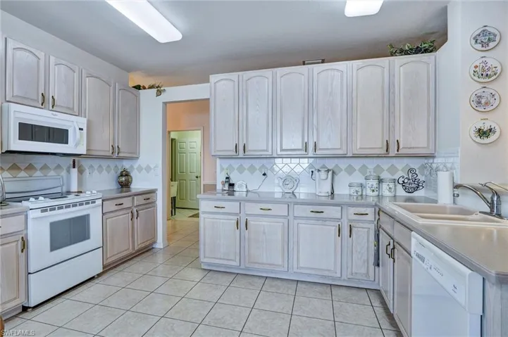 Kitchen featuring extensive light-finish cabinetry, tile flooring, and laminate countertops