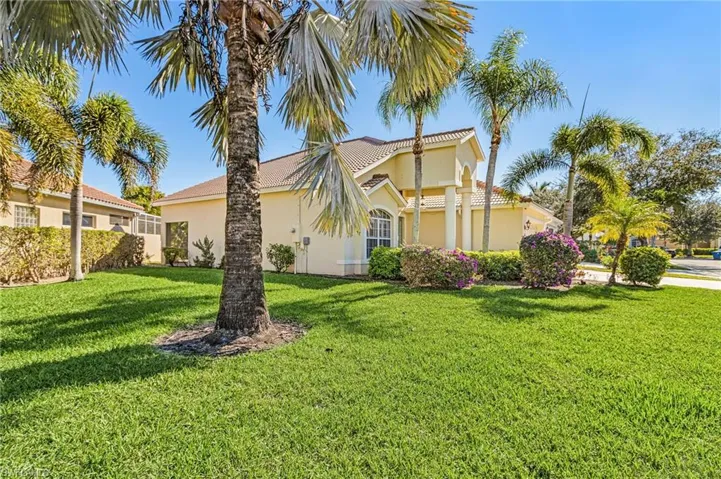 View of side of property featuring stucco siding and a lawn