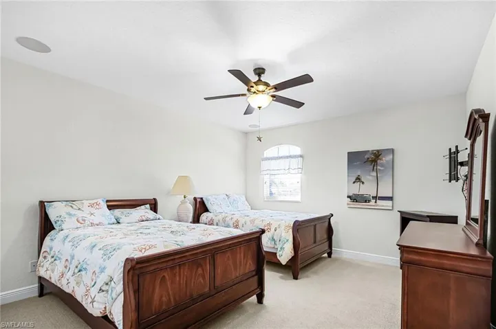 Carpeted bedroom with baseboards and ceiling fan