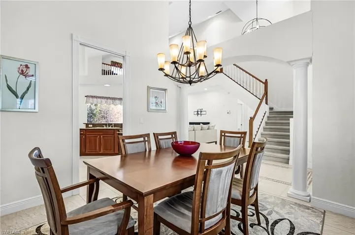 Dining space with ornate columns, suspended lighting, and a high ceiling
