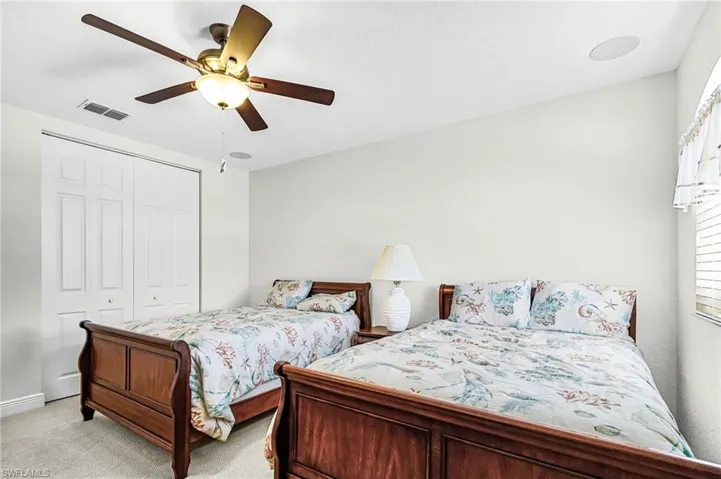 Bedroom featuring ceiling fan, light colored carpet, and a closet