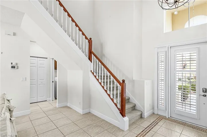 Entryway featuring light tile patterned floors and a high ceiling