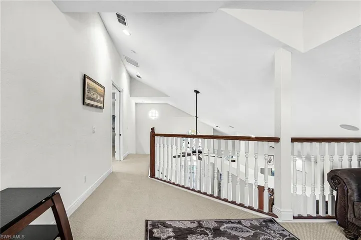 Hall with carpet and vaulted ceiling