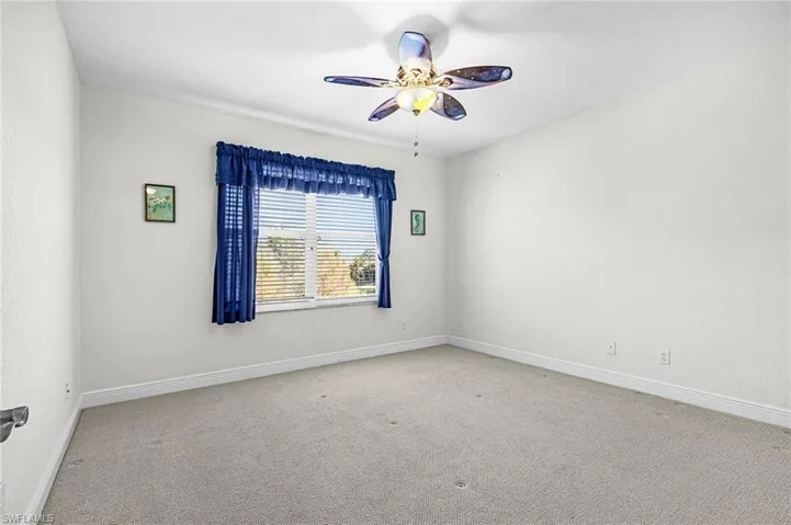 Empty room featuring ceiling fan and carpet
