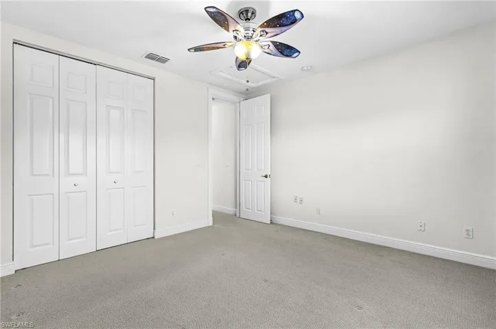Unfurnished bedroom featuring carpet, ceiling fan, and a closet