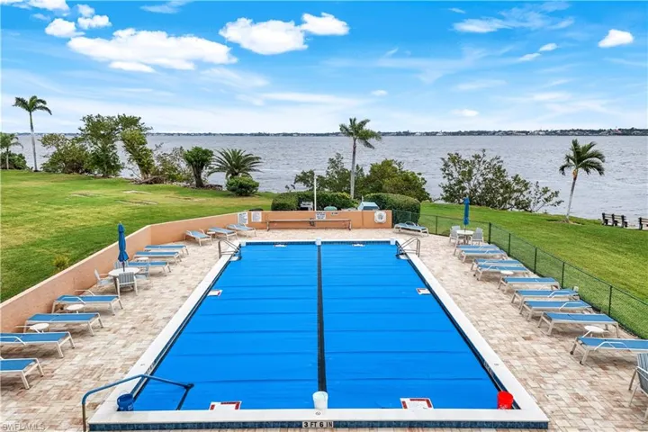 View of pool with a water view and a patio