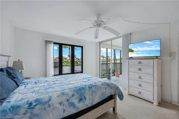 Bedroom featuring light carpet, access to outside, and ceiling fan