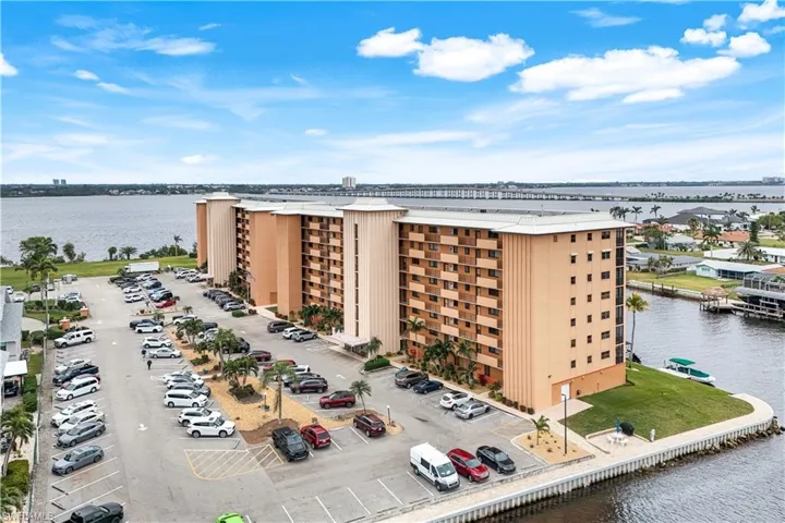 View of property with a water view and uncovered parking