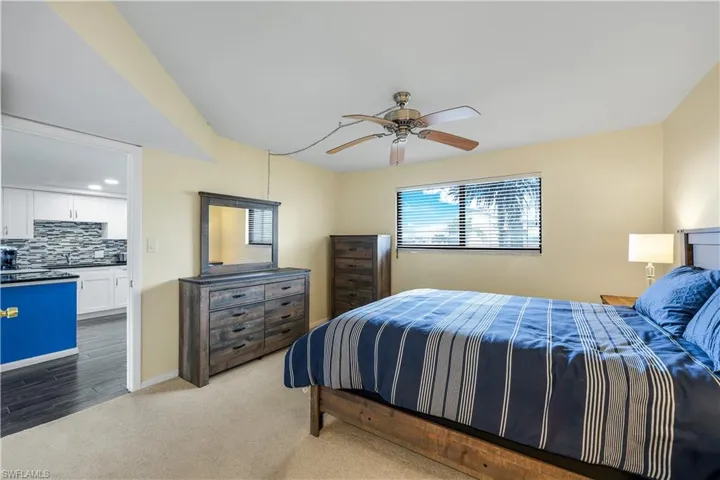 Carpeted bedroom featuring a sink and ceiling fan