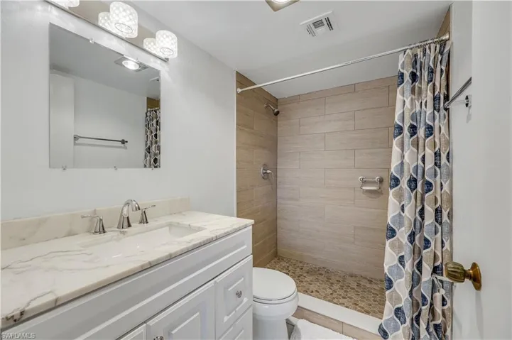 Full bathroom featuring vanity and tiled shower