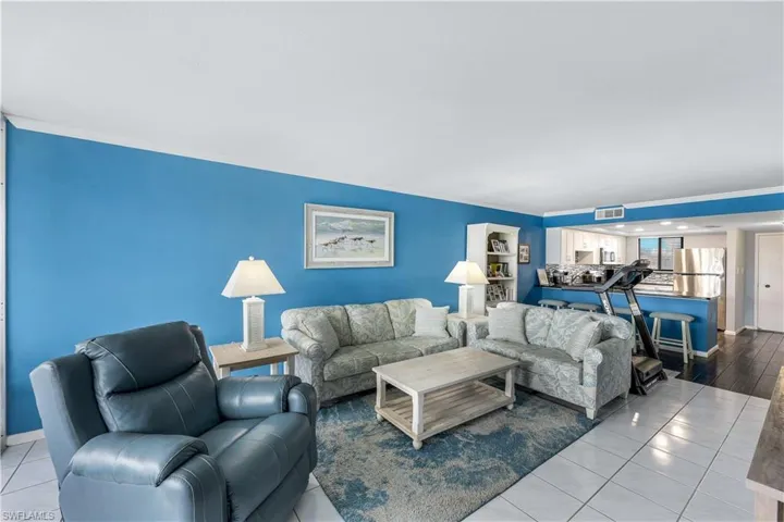 Living room with tile patterned floors and ornamental molding