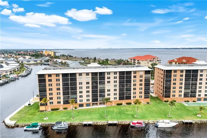 Drone / aerial view of apartment complex / building and a nearby body of water