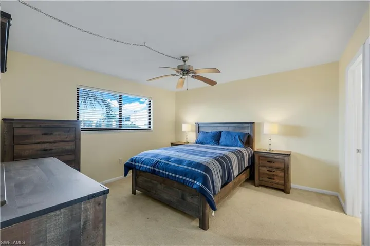 Bedroom with light colored carpet and a ceiling fan