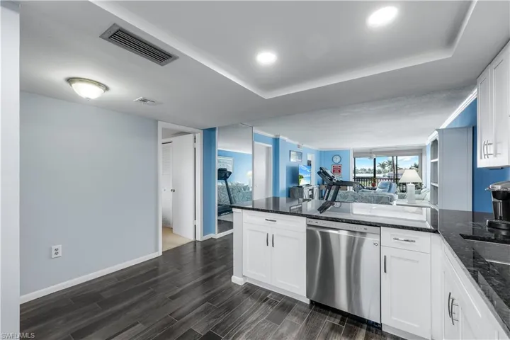 Kitchen featuring dishwasher, open floor plan, a peninsula, white cabinets, and recessed lighting