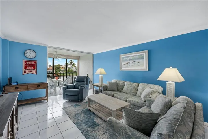 Living room featuring ornamental molding and light tile patterned flooring