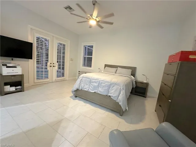 Large master bedroom with French doors leading directly out to pool area.