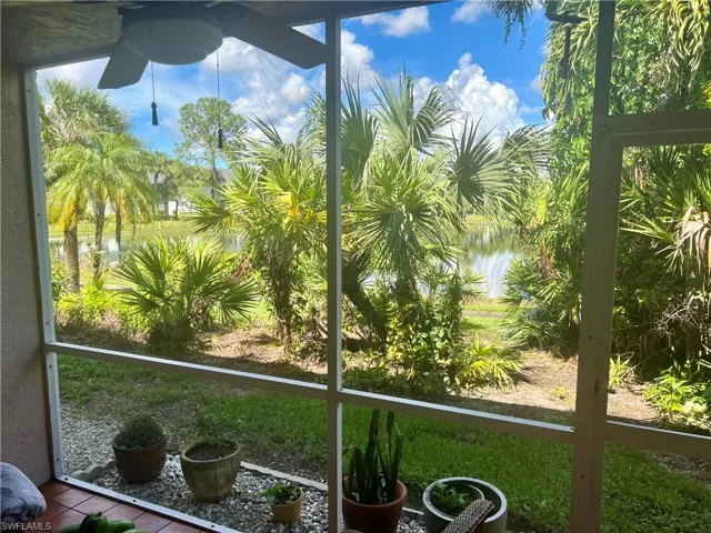 Unfurnished sunroom featuring a water view, ceiling fan, and a healthy amount of sunlight