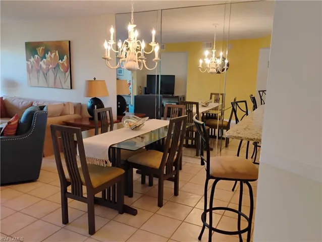 Tiled dining space featuring a chandelier