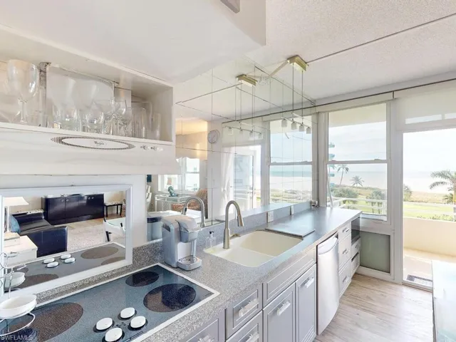 Kitchen featuring dishwasher, sink, a textured ceiling, light hardwood / wood-style floors, and cooktop