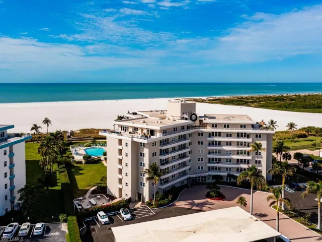 Aerial view featuring a beach view and a water view
