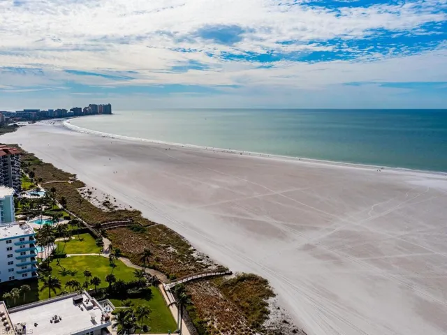 Birds eye view of property featuring a beach view and a water view