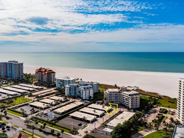 Birds eye view of property with a water view and a beach view