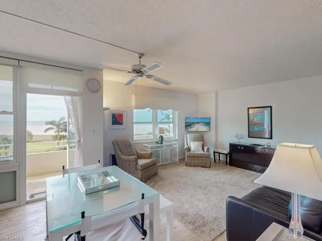 Living room featuring ceiling fan, light wood-type flooring, and a textured ceiling
