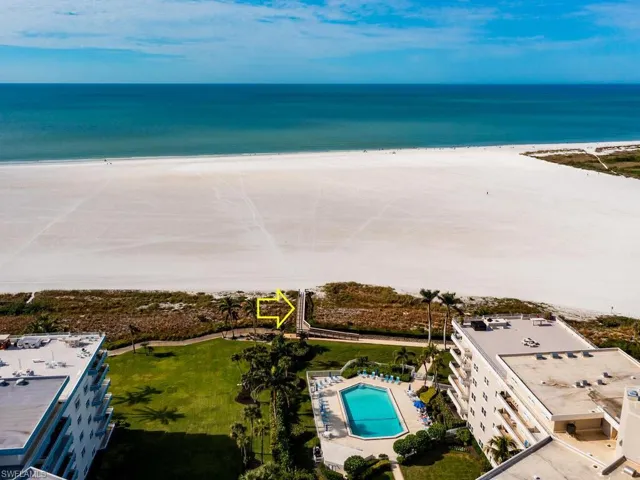 Birds eye view of property featuring a water view and a beach view