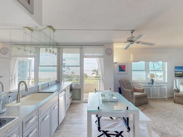 Kitchen featuring dishwasher, sink, ceiling fan, a textured ceiling, and white cabinetry