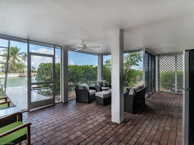 Sunroom featuring ceiling fan and a water view