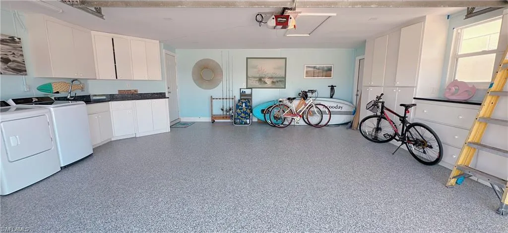 Garage featuring washer and dryer, a garage door opener, and a sink