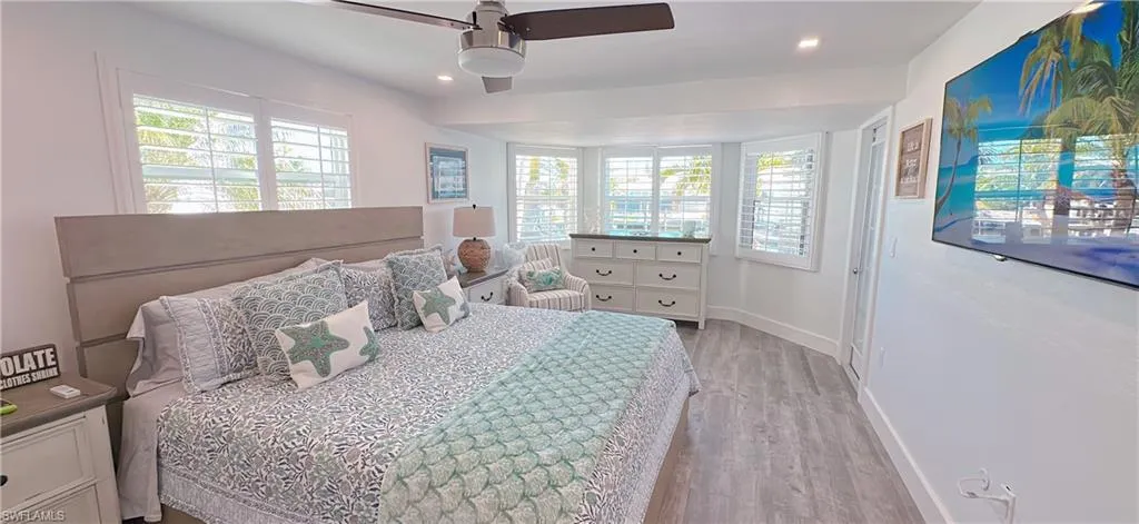 Bedroom with recessed lighting, baseboards, multiple windows, and light wood finished floors