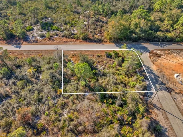 View of property location featuring property parcel outlined and a heavily wooded area