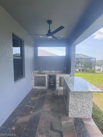 View of patio / terrace with exterior kitchen, a sink, and ceiling fan