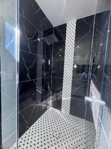 Details with tiled shower and a textured ceiling