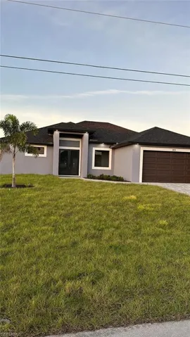View of front of property featuring a front yard and a garage