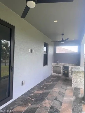 View of patio / terrace with ceiling fan, an outdoor kitchen, and a sink