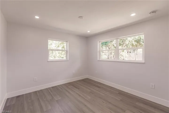 Unfurnished room featuring hardwood / wood-style flooring and a wealth of natural light