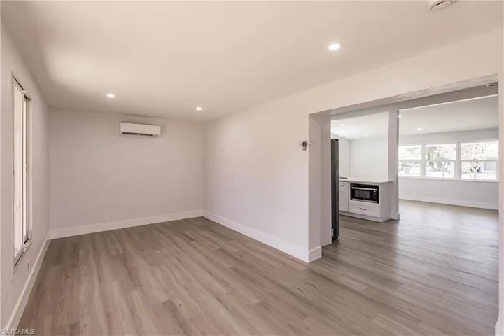 Unfurnished room featuring hardwood / wood-style flooring and a wall mounted air conditioner