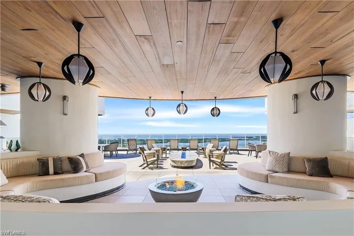 An upscale rooftop terrace features a fire element and hot tub, providing a refined space for outdoor relaxation and entertaining.